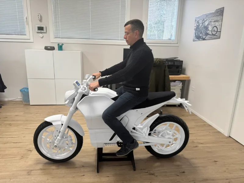 man sitting on static prototype of an electric motorcycle